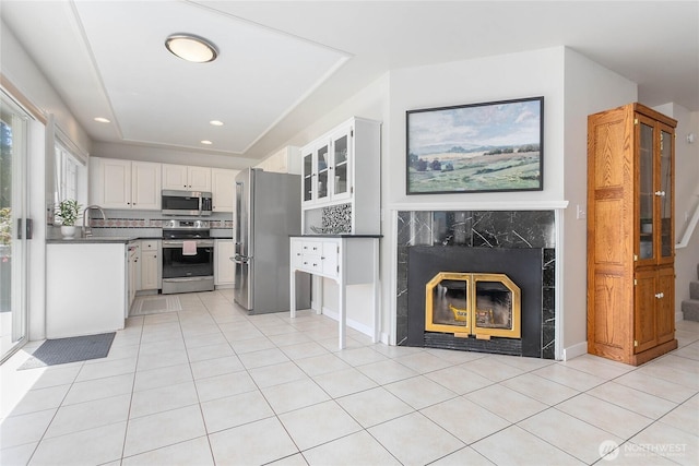 562 W Lake Samish Dr, Bellingham, WA 98229 - kitchen with stainless steel appliances, light tile patterned floors, white cabinets, glass insert cabinets, and recessed lighting