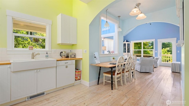 10539 N Madison Ave NE, Bainbridge Island, WA 98110 - kitchen featuring dishwasher, arched walkways, light wood-type flooring, and plenty of natural light