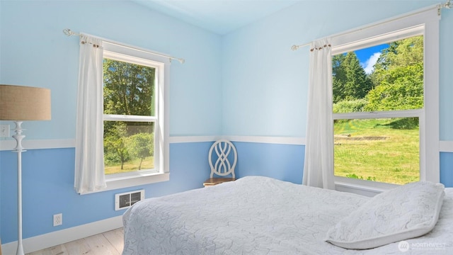 10539 N Madison Ave NE, Bainbridge Island, WA 98110 - bedroom featuring multiple windows, wood finished floors, and baseboards