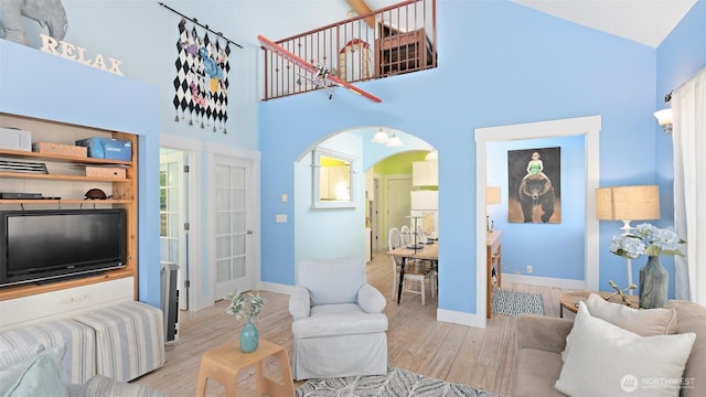 10539 N Madison Ave NE, Bainbridge Island, WA 98110 - living room with arched walkways, wood finished floors, a high ceiling, and baseboards