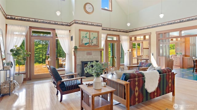 10539 N Madison Ave NE, Bainbridge Island, WA 98110 - living area with healthy amount of natural light, wood-type flooring, high vaulted ceiling, french doors, and a fireplace