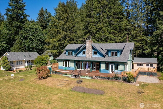 10539 N Madison Ave NE, Bainbridge Island, WA 98110 - view of front of property with a chimney, a front yard, roof with shingles, and a view of trees