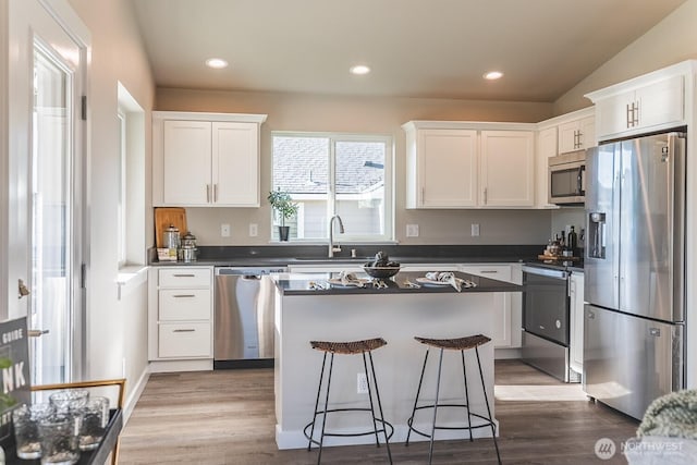 123 E 9th Ave Unit 67, Moses Lake, WA 98837 - kitchen featuring stainless steel appliances, a sink, a kitchen island, dark countertops, and white cabinetry
