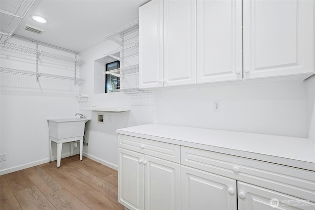 13206 SE 57th St, Bellevue, WA 98006 - washroom with hookup for a washing machine, light wood-type flooring, baseboards, cabinet space, and recessed lighting