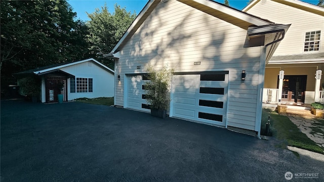 10920 Chaucer St SE, Olympia, WA 98501 - view of side of property with asphalt driveway and an attached garage