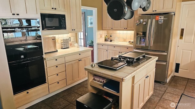 10920 Chaucer St SE, Olympia, WA 98501 - kitchen with tile countertops, black appliances, decorative backsplash, dark stone finish floors, and a kitchen island