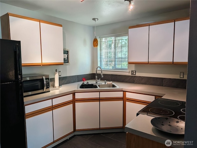10920 Chaucer St SE, Olympia, WA 98501 - kitchen featuring stainless steel microwave, freestanding refrigerator, a sink, white cabinetry, and light countertops