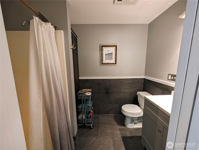 10920 Chaucer St SE, Olympia, WA 98501 - bathroom featuring toilet, tile walls, vanity, a wainscoted wall, and a shower with shower curtain