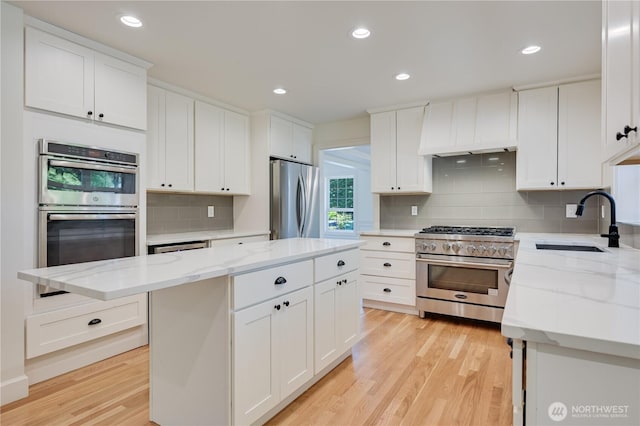 16710 Snohomish Ave, Snohomish, WA 98296 - kitchen featuring appliances with stainless steel finishes, a sink, custom exhaust hood, light wood finished floors, and tasteful backsplash