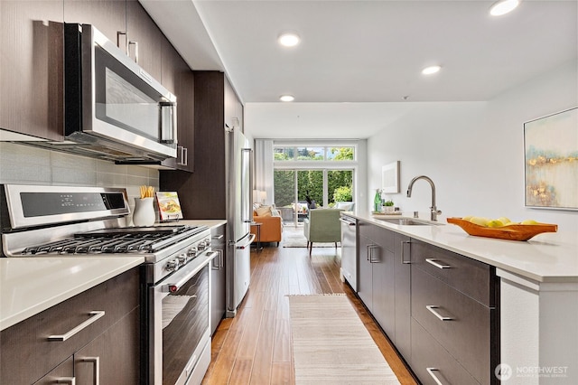 50 Pine St Unit 420, Edmonds, WA 98020 - kitchen with stainless steel appliances, a sink, modern cabinets, dark brown cabinetry, and recessed lighting