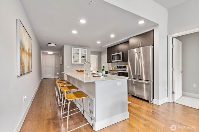 50 Pine St Unit 420, Edmonds, WA 98020 - kitchen with high quality appliances, a breakfast bar area, light countertops, baseboards, and recessed lighting