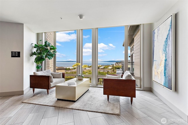 50 Pine St Unit 420, Edmonds, WA 98020 - living area featuring a water view, a wall of windows, baseboards, and wood tiled floors