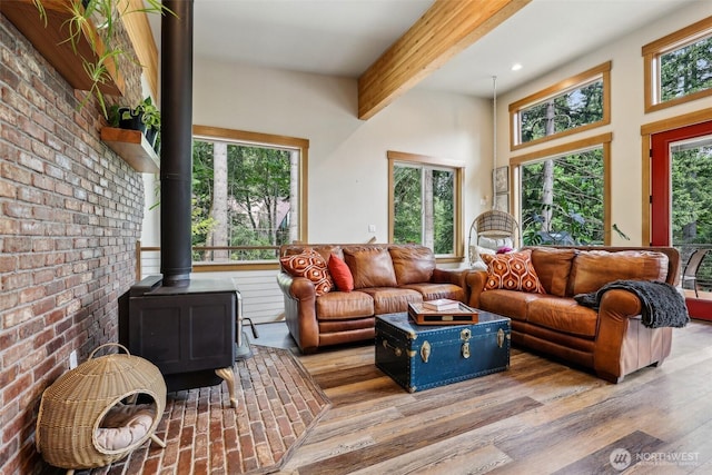 3271 Via Kachess Rd, Easton, WA 98925 - living area featuring a wood stove, beam ceiling, wood finished floors, brick wall, and recessed lighting