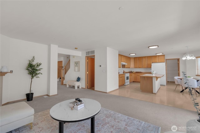 22111 96th Pl S, Kent, WA 98031 - living room with light colored carpet, stairway, baseboards, and a chandelier