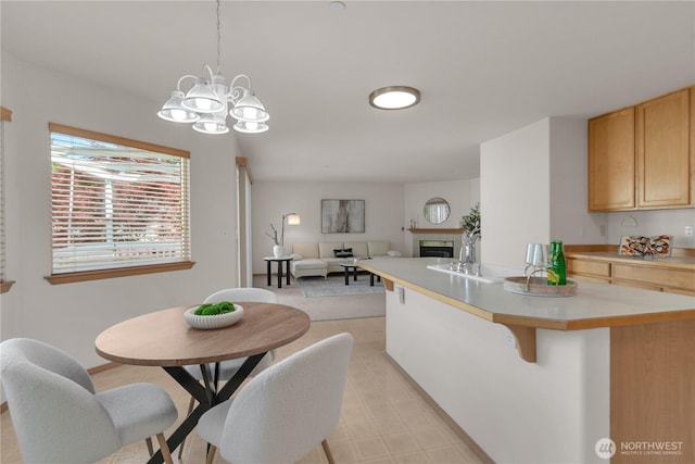 22111 96th Pl S, Kent, WA 98031 - kitchen with light countertops, a tiled fireplace, a chandelier, pendant lighting, and a kitchen breakfast bar