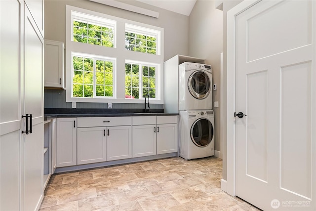 761 Chuckanut Dr, Bellingham, WA 98229 - laundry room with estacked washer and dryer, cabinet space, baseboards, and stone finish floors