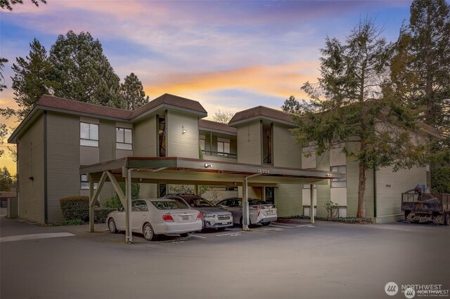 18904 8th Ave NW Unit 128, Shoreline, WA 98177 - view of front facade featuring covered parking, a shingled roof, and mansard roof