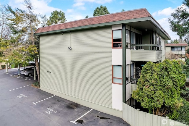 18904 8th Ave NW Unit 128, Shoreline, WA 98177 - view of side of home featuring a shingled roof, uncovered parking, and mansard roof