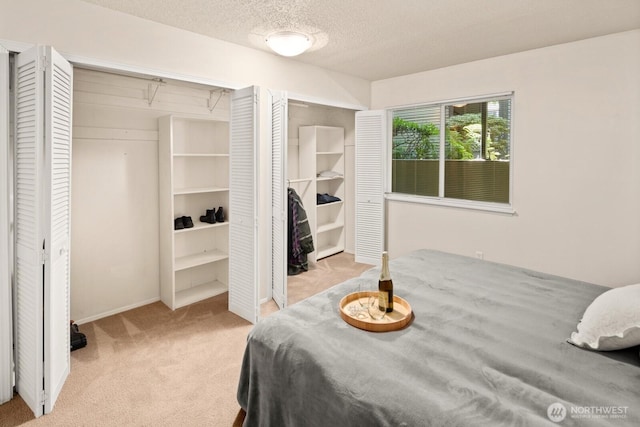 18904 8th Ave NW Unit 128, Shoreline, WA 98177 - carpeted bedroom featuring multiple closets and a textured ceiling