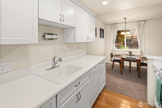 18904 8th Ave NW Unit 128, Shoreline, WA 98177 - kitchen with dishwasher, light countertops, white cabinets, recessed lighting, and decorative light fixtures