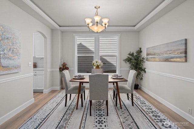 9304 S 223rd Pl, Kent, WA 98031 - dining area featuring light wood-style floors, a chandelier, baseboards, arched walkways, and ornamental molding
