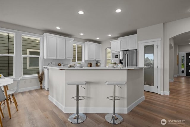 9304 S 223rd Pl, Kent, WA 98031 - kitchen featuring stainless steel refrigerator with ice dispenser, arched walkways, white cabinets, light wood-style flooring, and recessed lighting