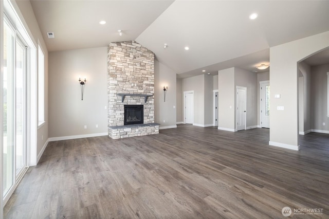 7514 Avalon Heights Way, Sedro Woolley, WA 98284 - unfurnished living room with vaulted ceiling, arched walkways, dark wood-style flooring, a stone fireplace, and baseboards