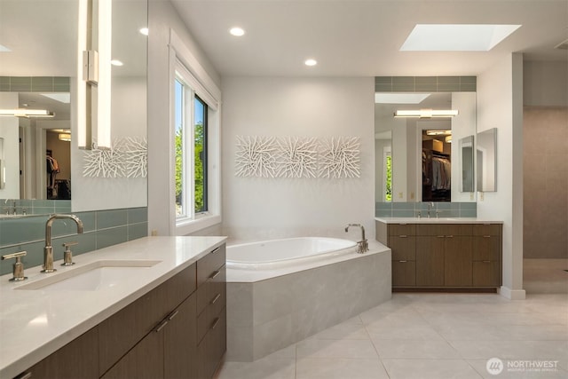9420 NE 31st St, Clyde Hill, WA 98004 - bathroom featuring a skylight, a garden tub, two vanities, tile patterned floors, and a spacious closet