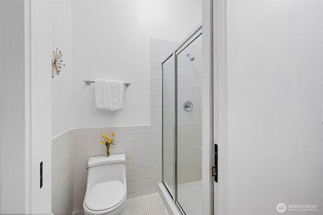 129 Warren Ave N Unit 18, Seattle, WA 98109 - bathroom featuring a stall shower, toilet, tile walls, and tile patterned floors