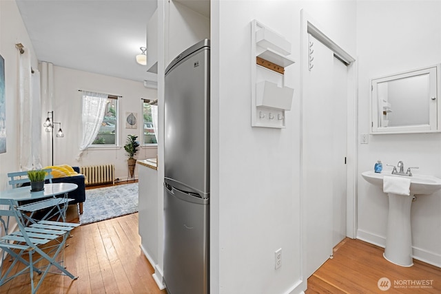 129 Warren Ave N Unit 18, Seattle, WA 98109 - corridor featuring radiator heating unit, light wood-style flooring, and baseboards