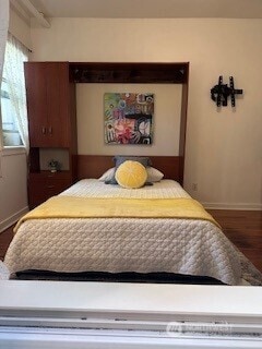 129 Warren Ave N Unit 18, Seattle, WA 98109 - bedroom with baseboards and dark wood-style flooring
