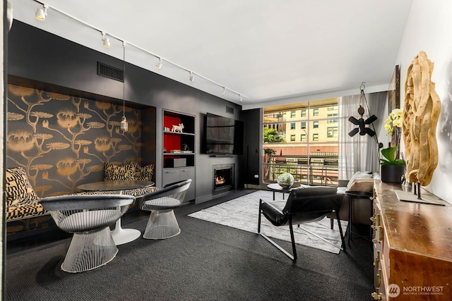 1425 Western Ave Unit L308, Seattle, WA 98101 - carpeted living area featuring rail lighting, a warm lit fireplace, and built in features
