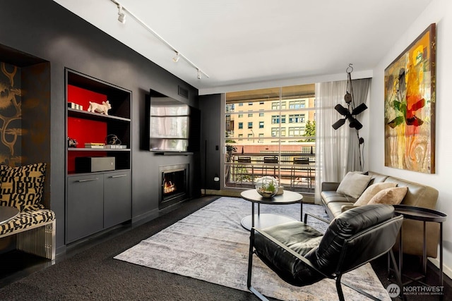 1425 Western Ave Unit L308, Seattle, WA 98101 - living area featuring track lighting, a lit fireplace, built in features, and baseboards