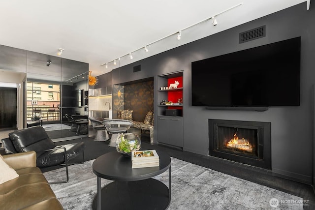 1425 Western Ave Unit L308, Seattle, WA 98101 - living area with rail lighting, a warm lit fireplace, and built in features