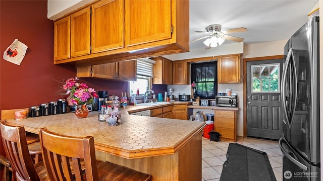 123 NE C St, College Place, WA 99324 - kitchen featuring stainless steel appliances, a peninsula, light tile patterned floors, ceiling fan, and light countertops