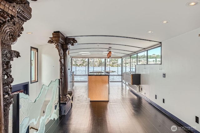 2040 Westlake Ave N Unit 26, Seattle, WA 98109 - kitchen featuring a wall of windows, recessed lighting, dark wood-style floors, dark countertops, and a kitchen island