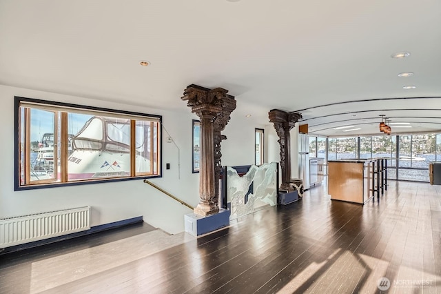 2040 Westlake Ave N Unit 26, Seattle, WA 98109 - unfurnished living room featuring decorative columns, radiator heating unit, wood finished floors, and recessed lighting