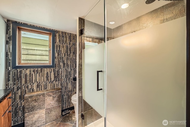 2040 Westlake Ave N Unit 26, Seattle, WA 98109 - bathroom featuring tile walls, a stall shower, and stone finish floors