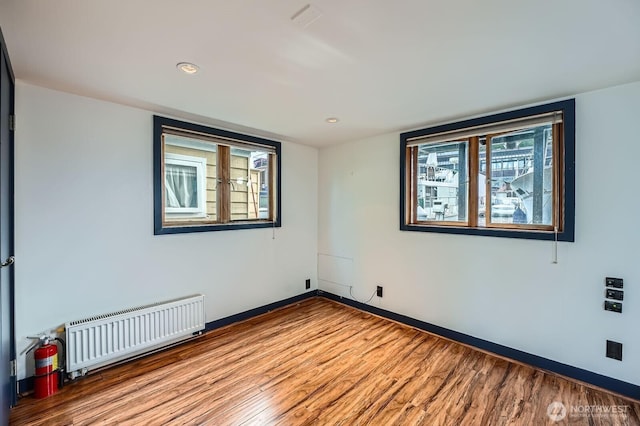 2040 Westlake Ave N Unit 26, Seattle, WA 98109 - unfurnished room with radiator, wood finished floors, and recessed lighting