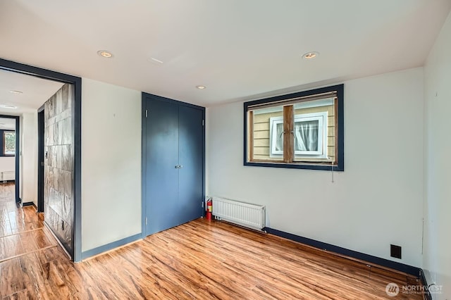 2040 Westlake Ave N Unit 26, Seattle, WA 98109 - unfurnished bedroom with radiator, wood finished floors, a closet, and recessed lighting