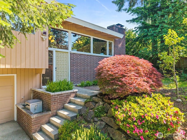 12508 SE 60th St, Bellevue, WA 98006 - view of side of home featuring a chimney, brick siding, and a garage
