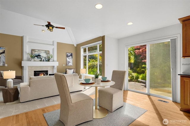 235 249th Pl NE, Sammamish, WA 98074 - dining room with light wood-type flooring, a tiled fireplace, vaulted ceiling, ceiling fan, and recessed lighting