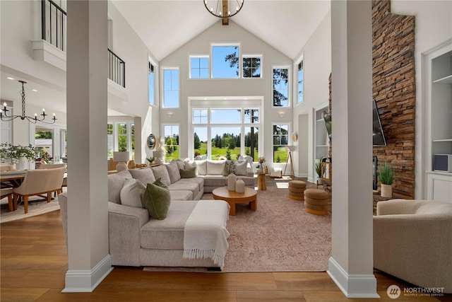 16006 288th St E, Graham, WA 98338 - living area featuring wood finished floors, high vaulted ceiling, a chandelier, and plenty of natural light