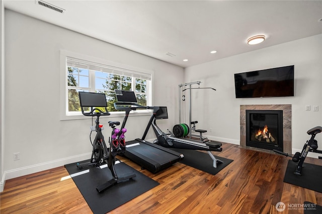 16006 288th St E, Graham, WA 98338 - workout room featuring a tile fireplace, wood finished floors, baseboards, and recessed lighting