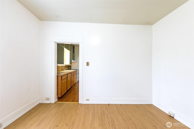 3827 S Morgan St, Seattle, WA 98118 - unfurnished room with light wood-style flooring, baseboards, and a sink