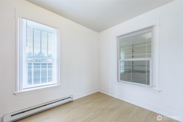 3827 S Morgan St, Seattle, WA 98118 - unfurnished room featuring a baseboard heating unit, wood finished floors, and baseboards