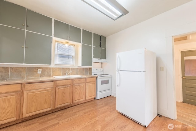 3827 S Morgan St, Seattle, WA 98118 - kitchen featuring white appliances, a sink, under cabinet range hood, light wood-style flooring, and light countertops