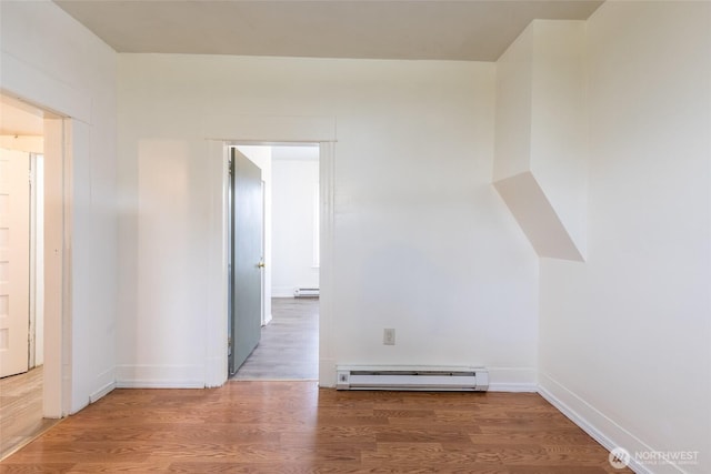 3827 S Morgan St, Seattle, WA 98118 - empty room with a baseboard heating unit, wood finished floors, a baseboard radiator, and baseboards