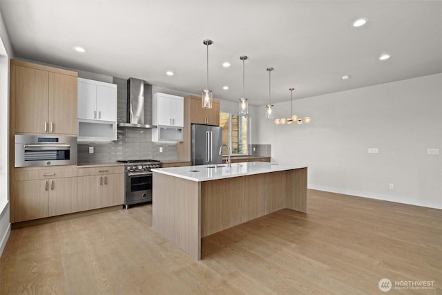 4570 22nd Ave SW, Seattle, WA 98106 - kitchen featuring wall chimney range hood, high quality appliances, recessed lighting, tasteful backsplash, and light wood-type flooring