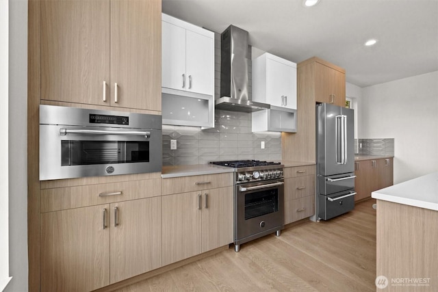 4570 22nd Ave SW, Seattle, WA 98106 - kitchen with premium appliances, wall chimney range hood, light wood-style floors, backsplash, and light countertops